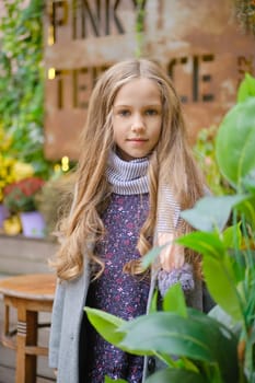Outdoor portrait of pretty little girl with long curly hair