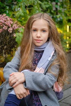 Outdoor portrait of cute little girl in coat and scarf