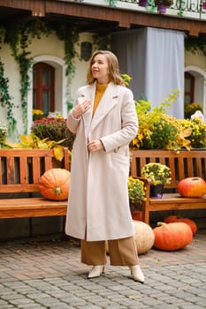 Young woman with unfastened coat at pumpkin festival