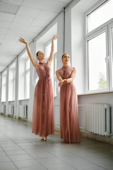 Two ballet dancers rehearsing choreography in the hallway