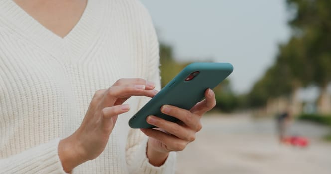 Woman uses mobile phone on street