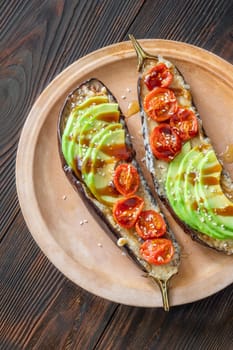 Baked eggplant with cheese, avocado and tomatoes