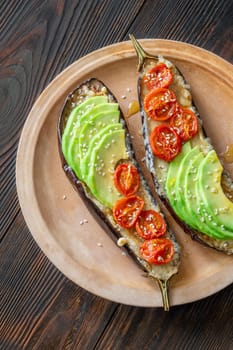 Baked eggplant with cheese, avocado and tomatoes