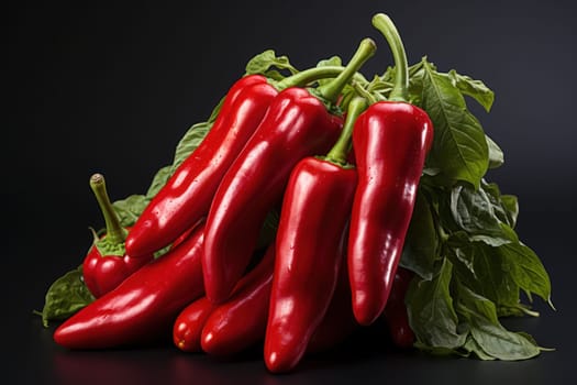 A group of glossy red peppers resting on lush green leaves, showcasing their vibrant and fresh appearance.
