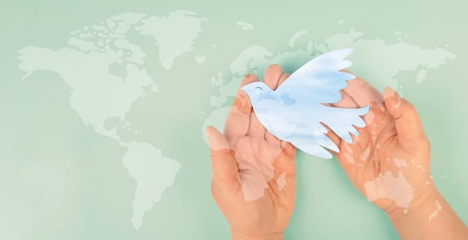 Dove flying from hand, international peace day, faith, freedom, charity and help concept, humanitarian aid, world map
