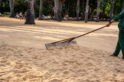 Smoothing the sand on the beach for beauty.