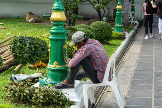 People are painting electric poles according to patterns. It is an electric pole that is in the temple.