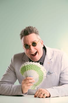 Smiling man in a suit deceitfully displays a fan of cash, enticing viewers with false promises of easy money