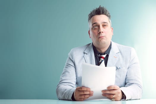 Confused anchorman in grey suit holds documents, his expression perplexed and slightly bewildered