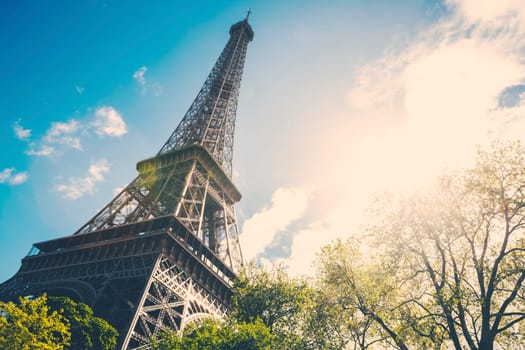 The Eiffel Tower in Paris, France during the morning with a strong lens flare.
