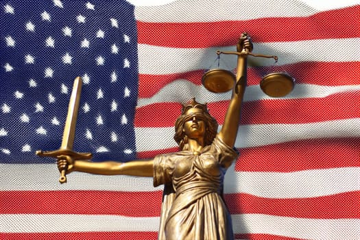 The Statue of Justice, Goddess of Justice in front of the USA flag.