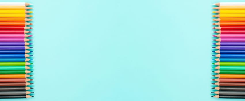 Color pencils collection in a row, back to school, drawing supplies, blue background with copy space