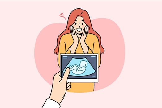 Pregnant woman rejoices after seeing intrauterine ultrasound image of son, and experiences joy of motherhood. Prenatal happiness of pregnant lady who finds out gender of baby for first time