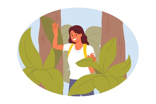 Woman went on forest hike or expedition, walks among trees and enjoys wild nature. Girl is interested in outdoor activities in exotic jungle, and goes on hike in search of adventure.