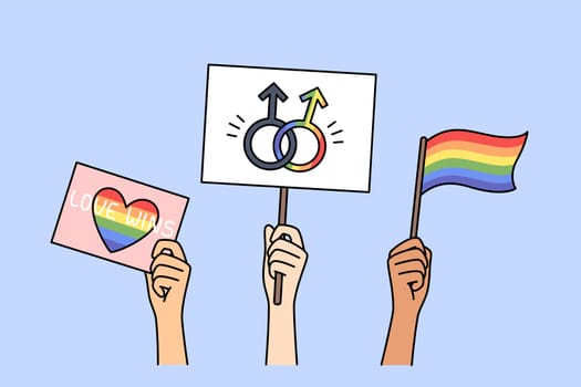LGBT posters and flags in hands of people, with images of rainbow symbols and inscription love wins. LGBT community celebrates pride month and calls for fighting for rights of LGBTq individuals