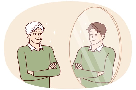 Elderly man stands in front of mirror and sees himself as young guy feeling surge of energy. Young guy looks at grandfather who looks like grandson or son for concept of generational heredity