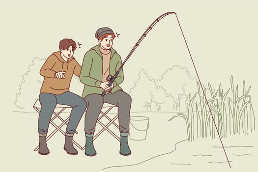 Son and father are fishing in lake, mouths open in anticipation of big catch at sight of fish. Two young friends relax in nature and fish, enjoying silence during to relaxation together