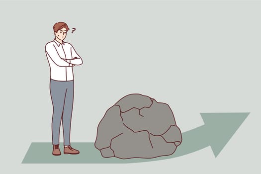 Obstacle to development for business man standing near giant stone that fell on arrow in front. Guy encounters obstacle when solving problem or advancing in courier service concept