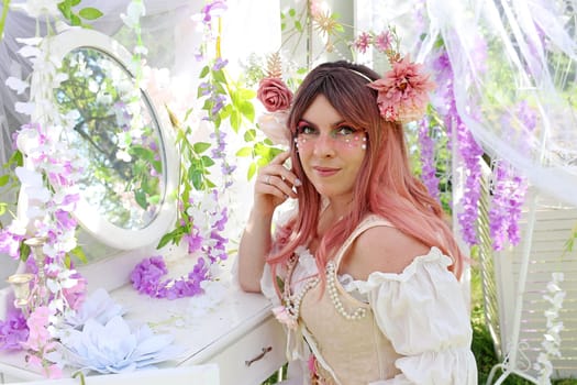 A tender, bright fairy or elf with flowers in front of a mirror