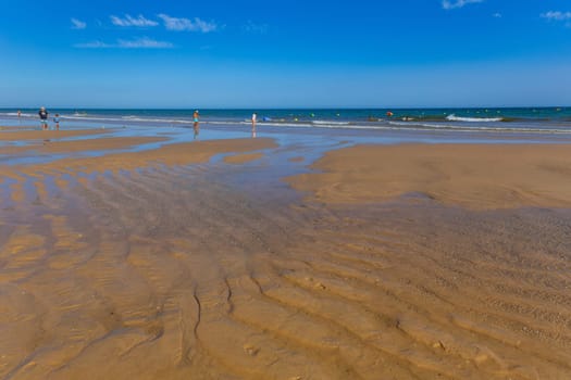 Tavira, Portugal - August 15, 2023: People at the famous beach of Tavira island in Tavira. This beach is a part of famous tourist region of Algarve.