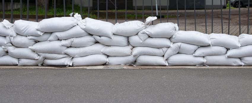Sandbags for flood defense, river Moselle Trier in Rhineland Palatinate, flooded trees and paths, high water level, climate change