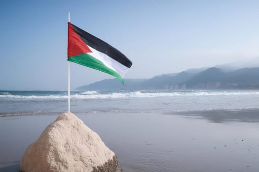 Flag of Palestine on a flagpole mounted on a stone against the background of the sea and mountains.