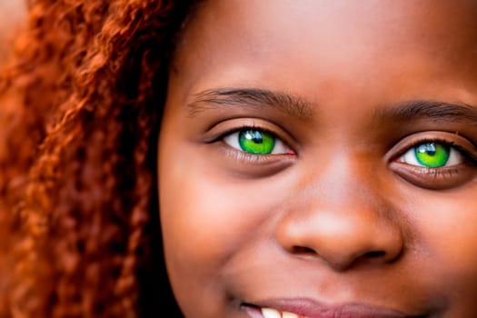 Green-eyed black girl with bright green eyes and afro hairstyle.