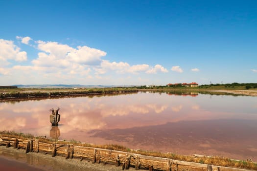 Perfect reflection of sky and clouds in the smooth surface of one of the pink pools at the Burgas Salt Pans at Lake Atanasovsko, Atanasovo, Burgas, Bourgas, Bulgaria 2022