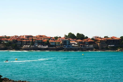 The old town of Sozopol, Sosopol next to the Sozopol Central Beach, water sports on the intense blue turquoise water in the foreground, Bulgaria 2022
