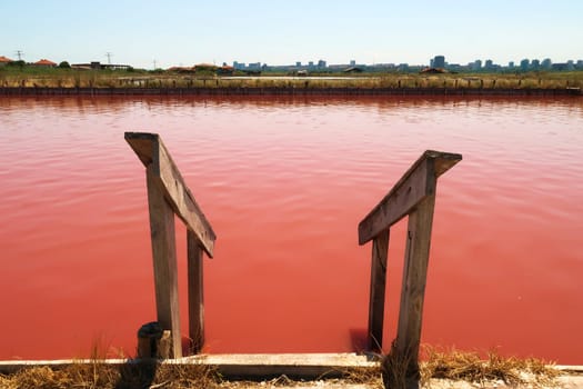 Stairs leading into the main bathing, swimming pool with its intense pink color at the Burgas Salt Pans, Lake Atanasovsko, Atanasovo, Burgas, Bourgas, Bulgaria 2022