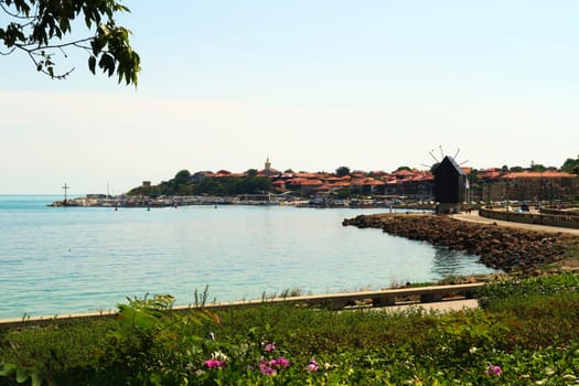 View onto Nessebar, Nesebar, the blue, turquoise sea, the road, the bridge and the Windmill can be seen in the foreground, the peninsula, old town in the background, Bulgaria 2022