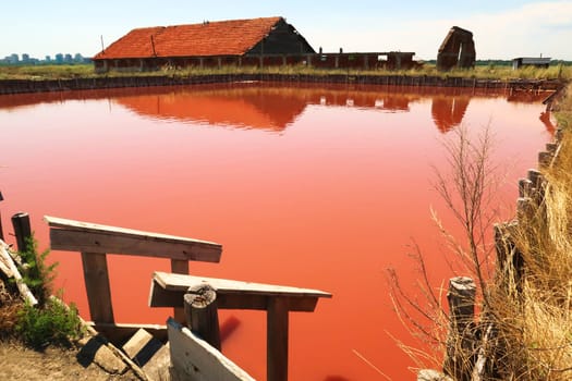 Wooden stairs leading into the main bathing, swimming pool with its intense pink color at the Burgas Salt Pans, Lake Atanasovsko, Atanasovo, Burgas, Bourgas, Bulgaria 2022
