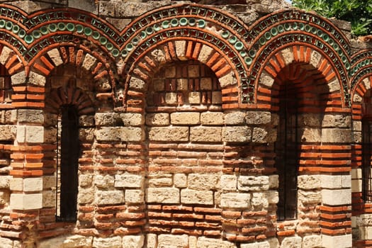 Patterns out of bricks and tiles decorate the elaborate facade of the Church of the Holy Archangels Michael and Gabriel in the old town of Nessebar, Nesebar, Bulgaria 2022