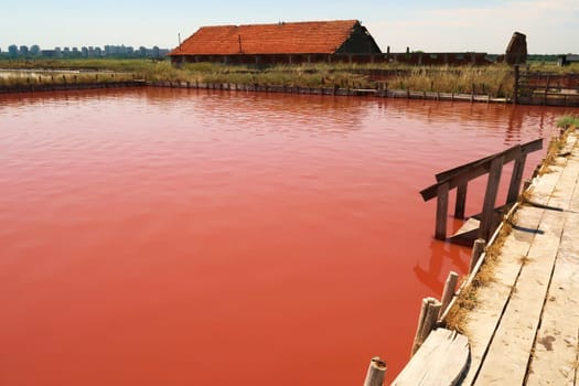 Board walk and stairs leading into the main bathing, swimming pool with its intense pink color at the Burgas Salt Pans, Lake Atanasovsko, Atanasovo, Burgas, Bourgas, Bulgaria 2022