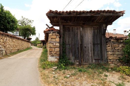 Big wooden gate, door in an old stone wall in the traditional village of Arbanasi, close to Veliko Tarnovo, Bulgaria 2022