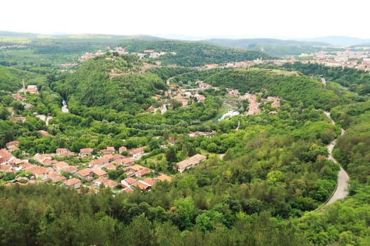 Picturesque view from the hiking trail along the Garga Bair Hill over the city of Veliko Tarnovo and the dense, lush forest that surrounds it, Veliko Tarnovo, Bulgaria 2022