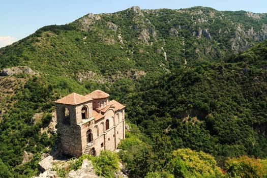 View onto the Church of the Holy Mother, part of the medieval Asen's, Asens Fortress, surrounded by mountains and dense, lush vegetation, forest, near Plovdiv, Bulgaria 2022