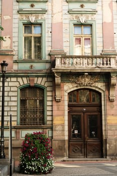 The wooden entrance door and the lower facade of the former Bulgarian National Bank building in the old town of Plovdiv, Plowdiw, Bulgaria 2022