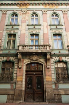 The beautiful facade of the former Bulgarian National Bank building, a big wooden door, a balcony and many windows, in the old town of Plovdiv, Plowdiw, Bulgaria 2022