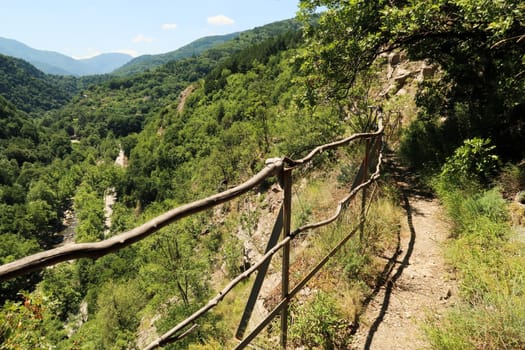 A wooden handrail between the narrow hiking trail from Asen's, Asens Fortress to Bachkovo Monastery and the gorge of the Chepelare River, Plovdiv, Plowdiw, Bulgaria 2022