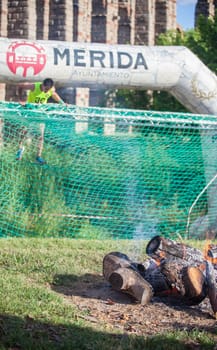 Merida, Spain - May 18th, 2024: FarinatoRace Merida 2024. Runner at finish line with a burning log