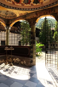 Beautiful entrance area of the St., Saint Nicolas, Nikola Church in one of the courtyards of the Bachkovo Monastery, frescos, ceiling paintings, pillars and elaborate metal grids, close to Plovdiv, Bulgaria 2022