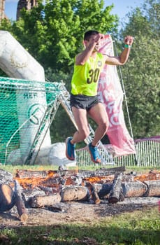 Merida, Spain - May 18th, 2024: FarinatoRace Merida 2024. Runner at finish line with a burning log