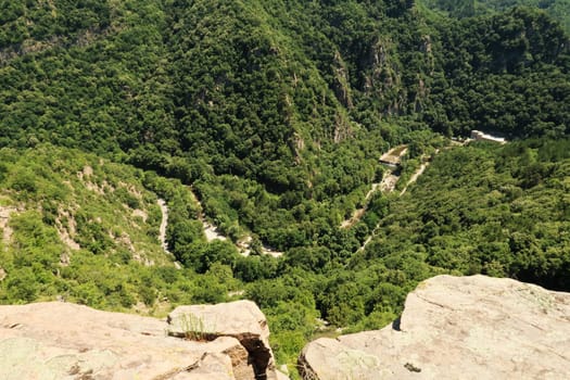 Spectacular view from the hiking trail between Asen's, Asens Fortress and the Bachkovo Monastery down onto the gorge of the winding Chepelare river, a hydroelectric power plant, dam can be seen, near Plovdiv, Bulgaria 2022