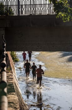 Merida, Spain - May 18th, 2024: FarinatoRace Merida 2024, Participants running along the Albarregas river