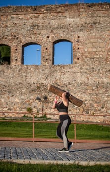 Merida, Spain - May 18th, 2024: FarinatoRace Merida 2024. Woman carrying a heavy log on his shoulder