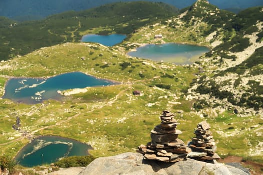 Two stacks, piles, pillars, towers of pebbles, stones at the Rila National Park, a view onto four of the Seven Rila Lakes can be seen in the background, close to Sofia, Bulgaria 2022