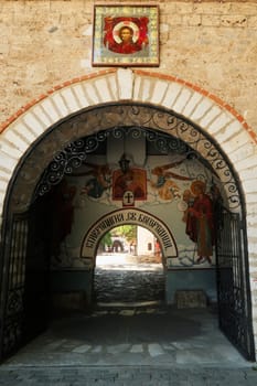 Entrance gate to the Bachkovo Monastery covered with a colorful fresco, wall painting depicting Archangel Michael and Gabriel attending the birth of Jesus, close to Plovdiv, Bulgaria, 16th of July 2022