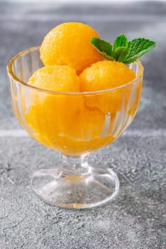 Mango sorbet scoop in the glass bowl