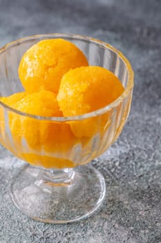 Mango sorbet scoop in the glass bowl